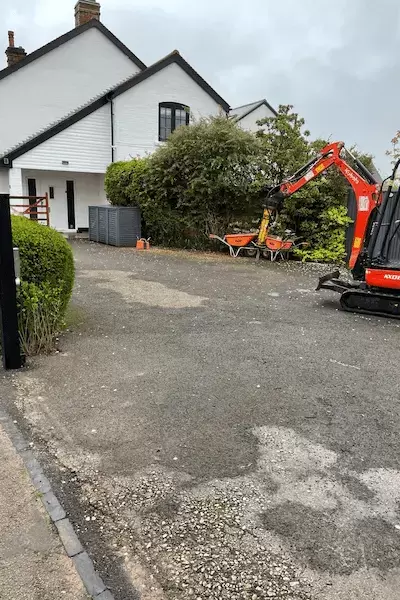 Front driveway entrance with tired worn out tarmac drive.